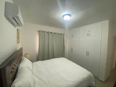 a white bedroom with a bed and a white cabinet at Apartamento completo en Bayahibe in Bayahibe