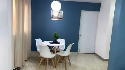 a dining room with a white table and white chairs at Departamento en el centro in Santiago de los Caballeros