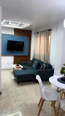 a living room with a blue couch and a tv at Departamento en el centro in Santiago de los Caballeros