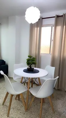 a white table with white chairs and a plant on it at Departamento en el centro in Santiago de los Caballeros