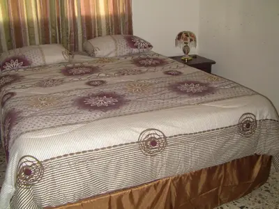 a bedroom with a large bed with purple and white sheets at Castillo Romano in Las Terrenas