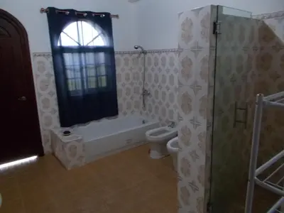 a bathroom with a tub and a toilet and a window at Castillo Romano in Las Terrenas