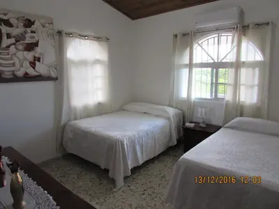 a bedroom with two beds and a window at Castillo Romano in Las Terrenas