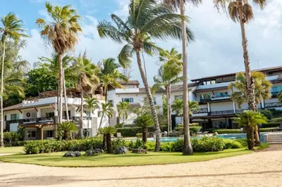 a resort with palm trees and a swimming pool at Penthouse frente al mar Playa Las Ballenas in Las Terrenas