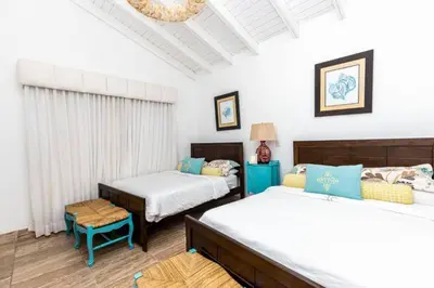 a bedroom with two beds and a blue chair at Penthouse frente al mar Playa Las Ballenas in Las Terrenas