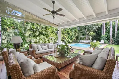 an outdoor patio with wicker furniture and a pool at Cozy Private Family Villa at Casa de Campo - Pool, BBQ, Golf Cart in La Romana