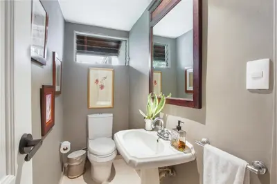 a bathroom with a sink and a toilet and a mirror at Cozy Private Family Villa at Casa de Campo - Pool, BBQ, Golf Cart in La Romana