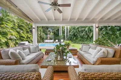 a patio with couches and a table and a pool at Cozy Private Family Villa at Casa de Campo - Pool, BBQ, Golf Cart in La Romana
