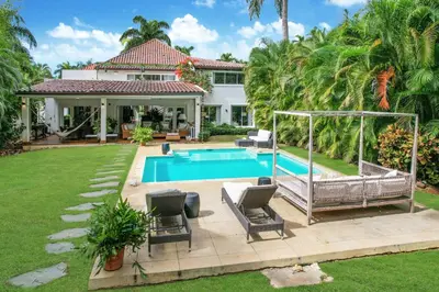 a backyard with a swimming pool and a house at Cozy Private Family Villa at Casa de Campo - Pool, BBQ, Golf Cart in La Romana