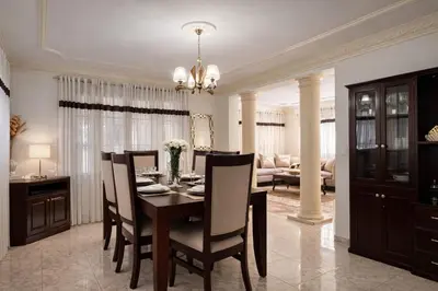 a dining room and living room with a table and chairs at casa Martinez refugio sereno in Santiago de los Caballeros