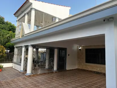 a white house with a gate and a balcony at casa Martinez refugio sereno in Santiago de los Caballeros