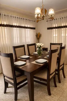 a dining room with a wooden table and chairs at casa Martinez refugio sereno in Santiago de los Caballeros