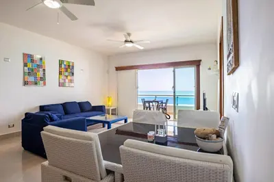 a living room with a blue couch and chairs at Beachfront Cabarete Apartment in Cabarete