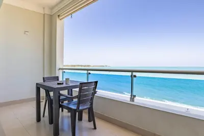 a table and chairs in a room with a view of the ocean at Beachfront Cabarete Apartment in Cabarete