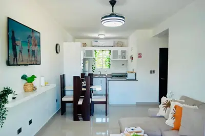 a living room and kitchen with a couch and a table at Serene Beach Apartment in La Romana