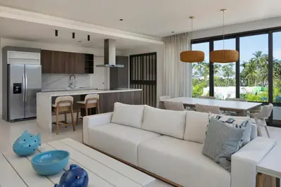 a living room with a white couch and a kitchen at Donoma Las Terrenas Beach Hotel & Spa, Autograph Collection in Las Terrenas