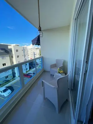 a room with a balcony with a chair and a window at Apartamento con terraza y jacuzzi privado in Santo Domingo