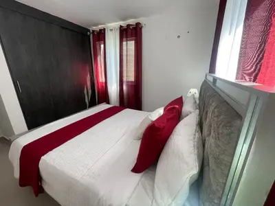 a bedroom with a bed with red and white pillows at Apartamento con terraza y jacuzzi privado in Santo Domingo