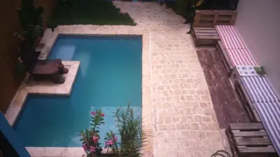 a large blue swimming pool in a house at La Choza Guesthouse in Santo Domingo