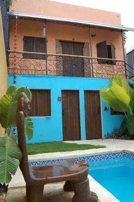 a house with a statue in front of a pool at La Choza Guesthouse in Santo Domingo