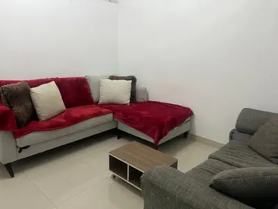 a living room with a red couch and a coffee table at Habitación económica in Santiago de los Caballeros
