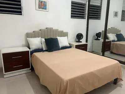 a bedroom with a large bed with blue pillows at Habitación económica in Santiago de los Caballeros