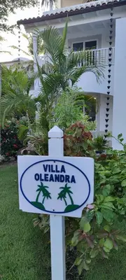 a sign in front of a house with a palm tree at Caribe Home Dominicus Oleandra 3 in La Laguna