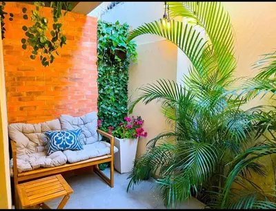 a couch sitting next to a brick wall with plants at Colonial leyton apartment in Santo Domingo