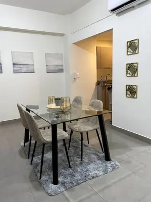 a dining room with a glass table and chairs at Luxury Santo Domingo Tower Condo in Santo Domingo
