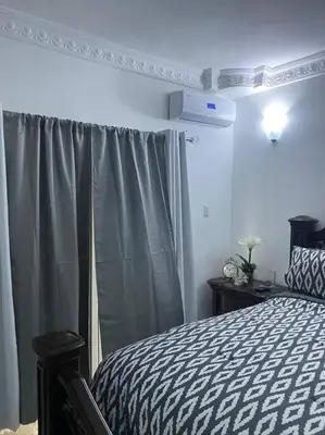 a bedroom with a black and white bed and a window at Modern Country Side Lux Apt in La Ceibita