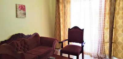 a living room with a couch and a chair and a window at Costambar Beachside Apartment with Pool in San Felipe de Puerto Plata