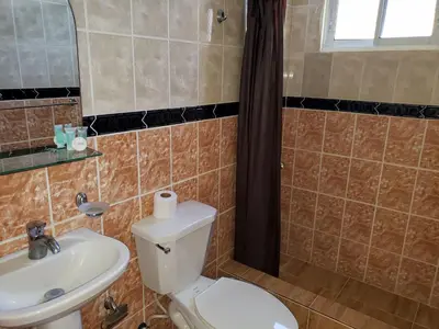 a bathroom with a toilet and a sink at Costambar Beachside Apartment with Pool in San Felipe de Puerto Plata