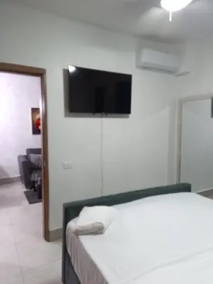 a bedroom with a bed and a flat screen tv on the wall at Boca del Mar III, apartamento 411 in Boca Chica