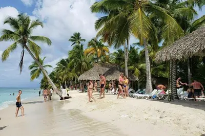 a group of people walking on a beach with palm trees at Boca del Mar III, apartamento 707 in Cuevas