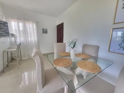 a dining room with a glass table and chairs at The Loft Bayaguana in Bayaguana