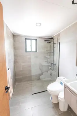 a bathroom with a shower and a toilet and a sink at Modern 2BR Apartment 3 Min from Airport with Free Parking in Sosúa