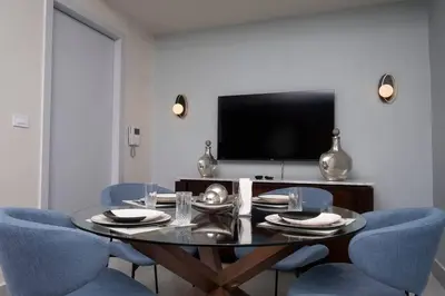 a dining room with a black table and blue chairs at Apartamento de 2H en el Centro de la Ciudad in Santo Domingo
