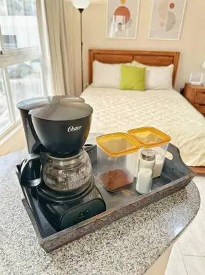 a coffee maker on a tray next to a bed at BEST Studio, Pool & Gym, River view from terrace in Calero