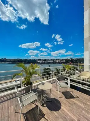 a balcony with chairs and a table and a view of the water at BEST Studio, Pool & Gym, River view from terrace in Calero