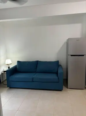 a blue couch in a room with a refrigerator at Apartment, Close to the Bayahibe Beach in Bayahibe