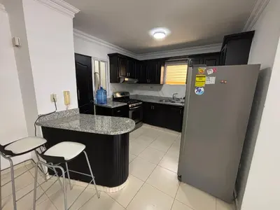 a kitchen with a counter and a refrigerator at Centrico con yacuzzi privado in Santiago de los Caballeros