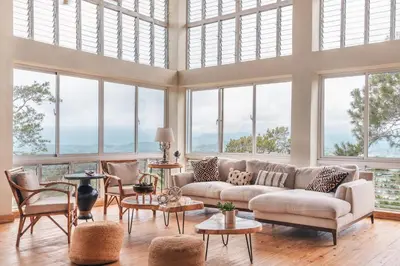 a living room with a couch and a lot of windows at Majestic villa with stunning views in Jarabacoa in Buena Vista