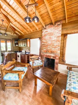 a living room with a brick fireplace and wooden ceilings at Villas Las Neblinas in Constanza