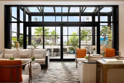 a lobby with couches and tables and windows at Hotel Santiago, Curio Collection By Hilton in Santiago de los Caballeros