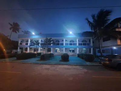 a large white building with palm trees at night at Cabrera 6 in Cabrera