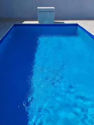 a blue swimming pool with a block in the water at Crown ll-3 Bedrooms-Pool-Close to everything! in San Felipe de Puerto Plata