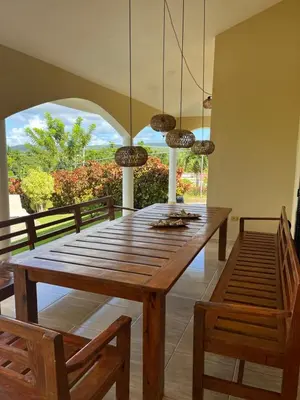 a dining room with a wooden table and two chairs at Villa Karolina in Las Galeras