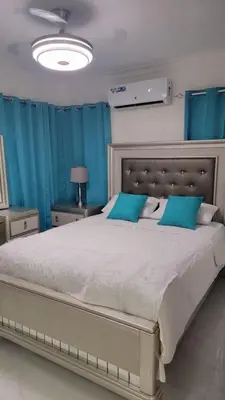 a bedroom with a large bed with blue curtains at Klinda Luxury Home Apartament Mi Casa es tu Casa in Mendoza