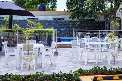a row of white tables and chairs and an umbrella at Villas Vallejuelo in Vallejuelo