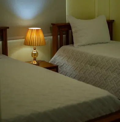 a bedroom with two beds and a table with a lamp at Villas Vallejuelo in Vallejuelo